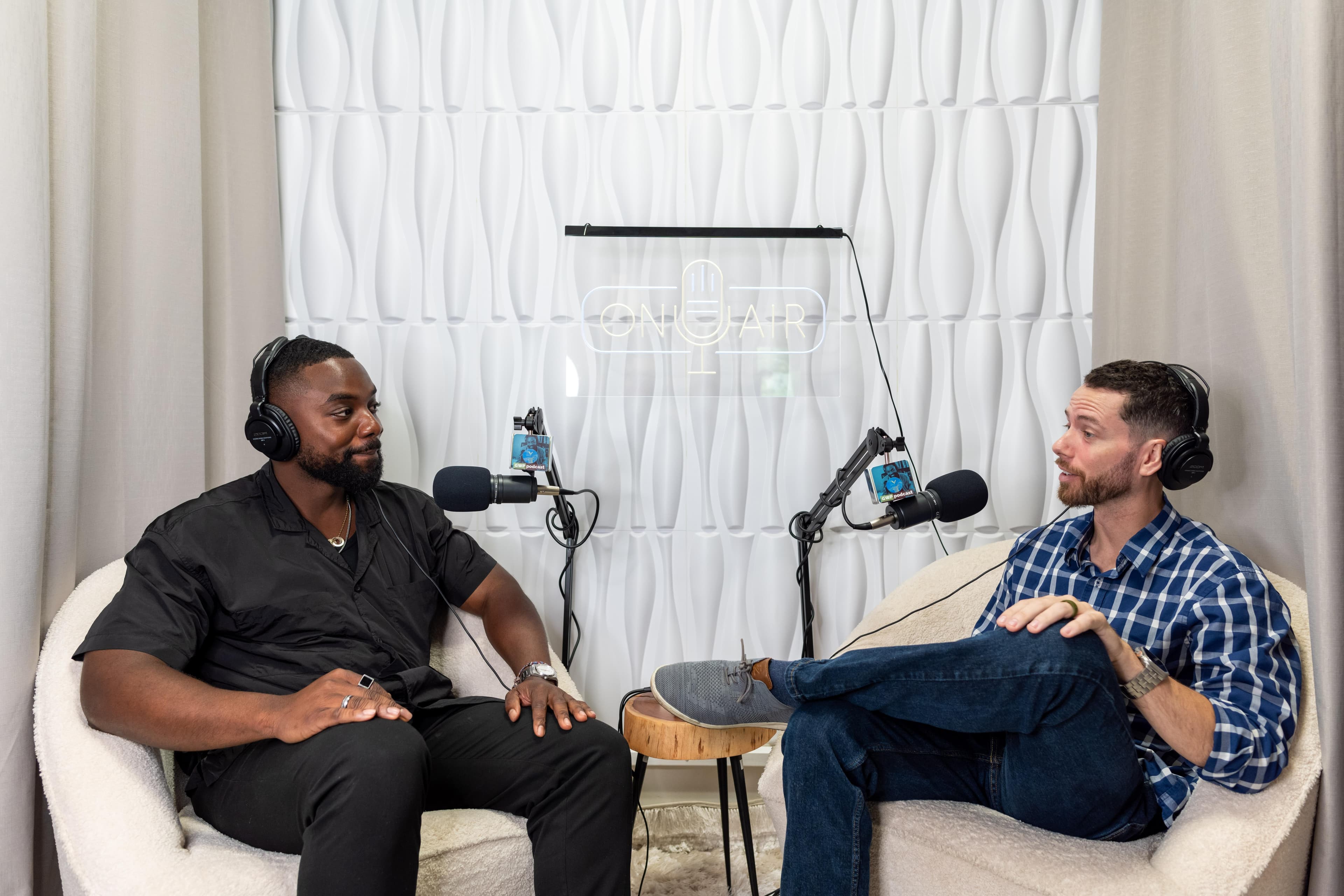 Papa and guest Will mid-conversation in headphones in the GWP studio, under an On Air sign.